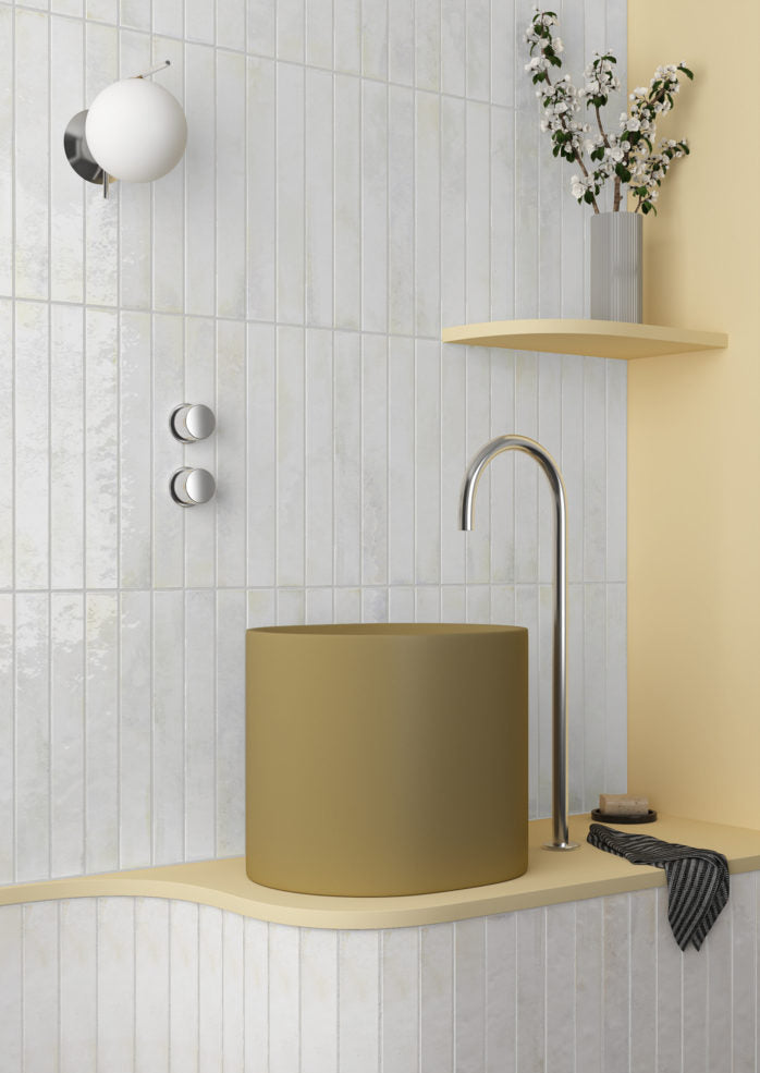 Bathroom corner with a green sink, silver faucet, and light wood shelves.