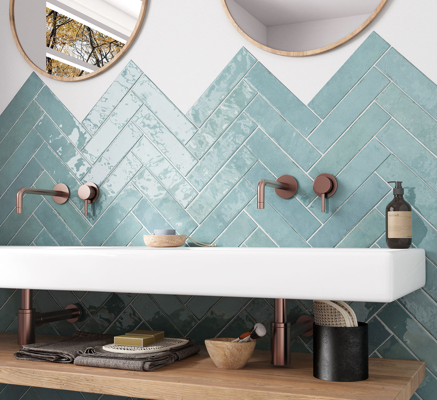 Bathroom with teal herringbone tiles, white sink, and wooden shelf.