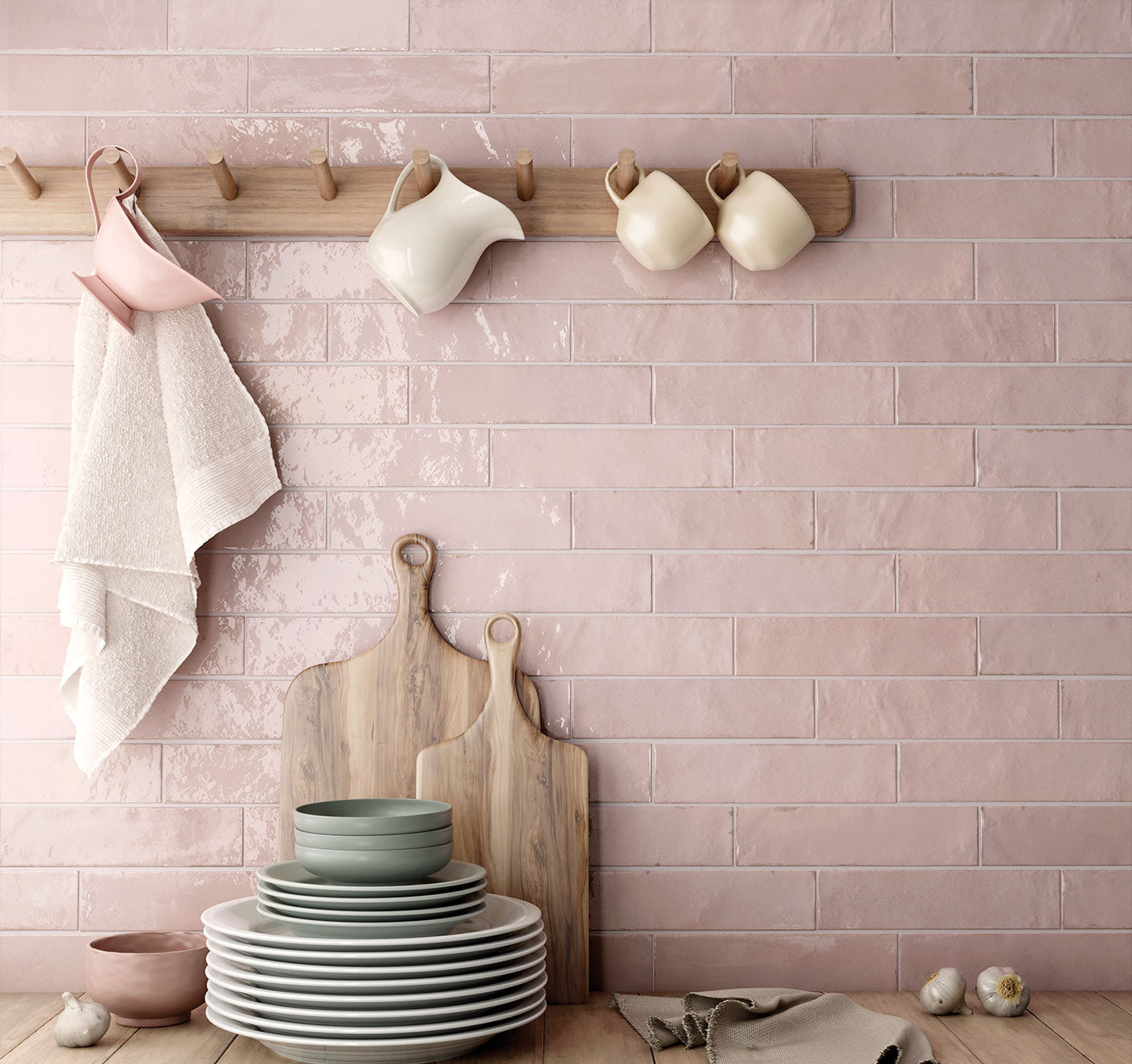 Kitchen setting with pink tiled wall, wooden rack with mugs, and stacked plates on a wooden surface.