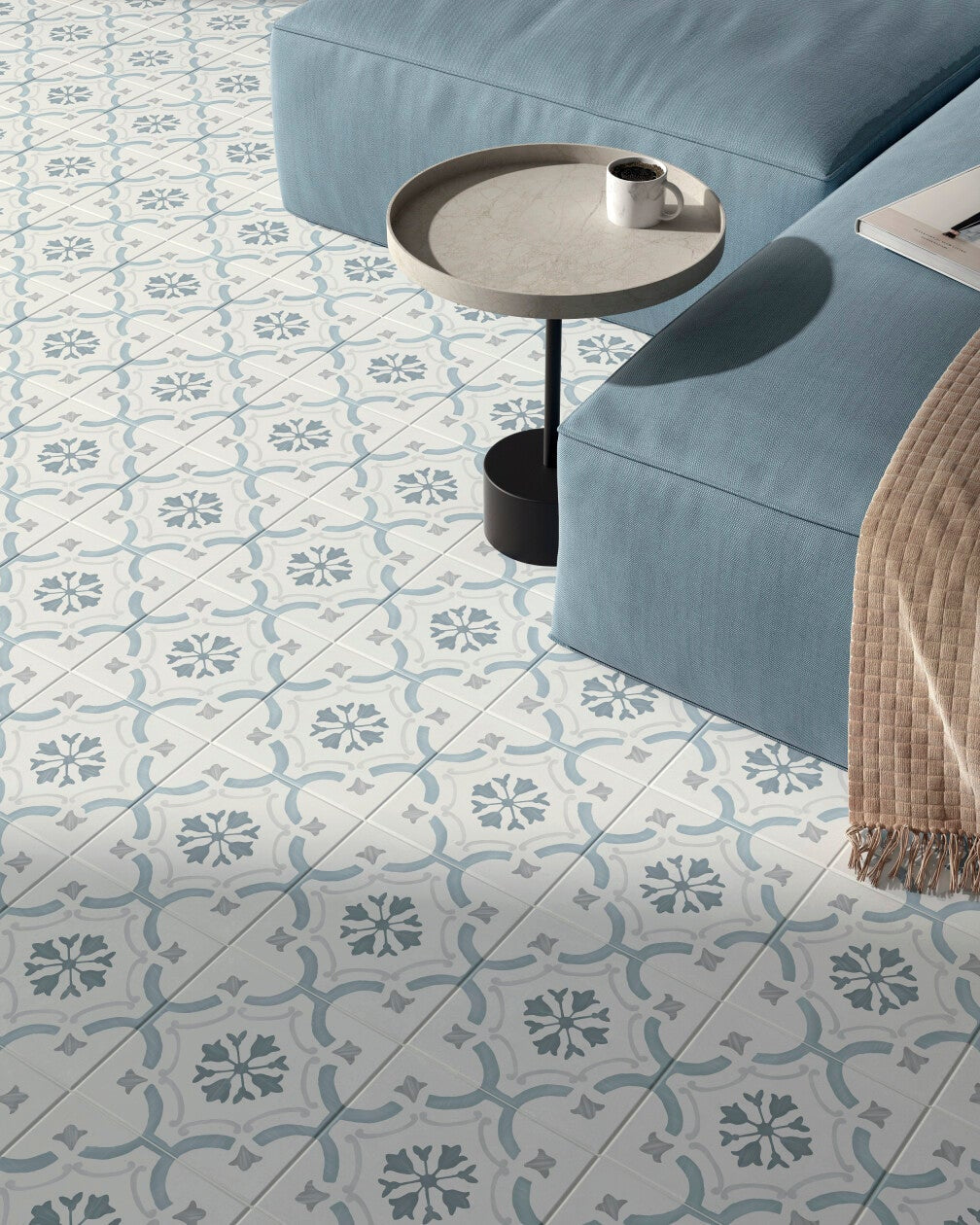 Living room with a patterned tile floor called tangier blue iris and a blue sofa.